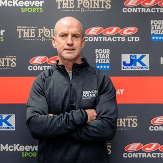 Benchmark coach at a sponsor wall