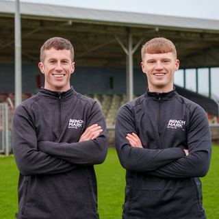 Two Benchmark coaches in front of a stand